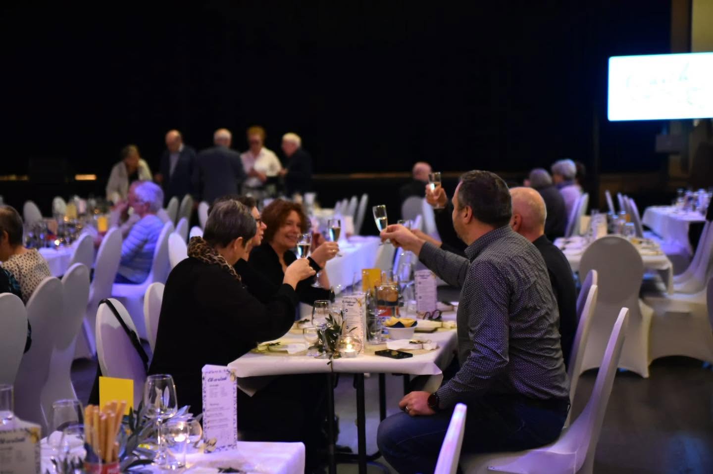 Bezoekers heffen het glas aan de feestelijk gedekte tafels