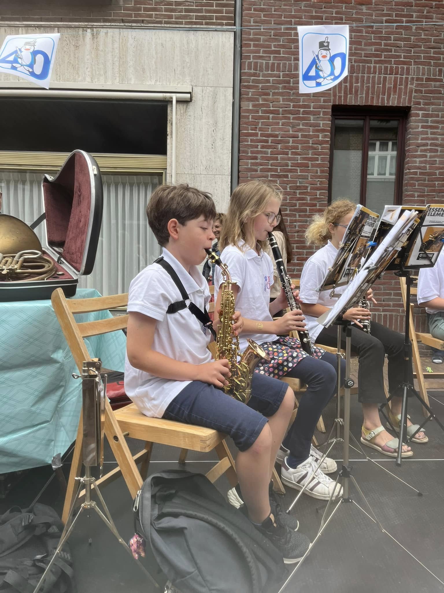 Jonge muzikanten van de blazersklas spelen samen saxofoon en klarinet